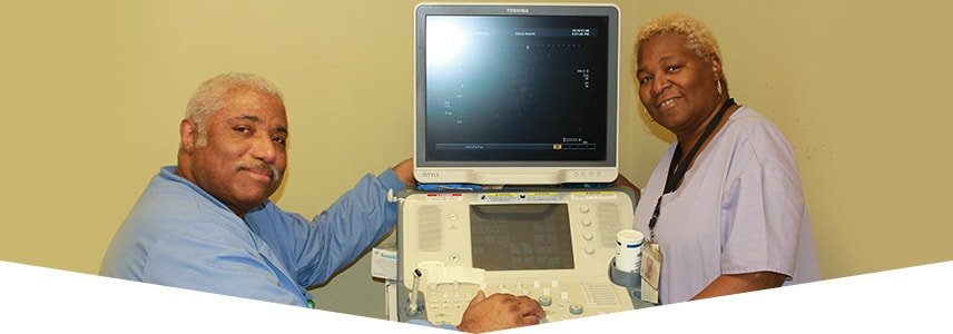 Two nurses next to a respiratory monitor